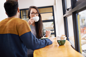 Image showing Couple, relax and date with coffee at cafe for morning conversation, bonding or romance at indoor restaurant. Man and woman drinking or enjoying caffeine, latte or cappuccino by window at the shop