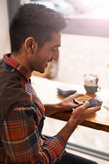 Image showing Happy man, coffee and typing with phone for social media, communication or networking at indoor cafe. Male person on mobile smartphone with smile for online chatting, texting or app at restaurant