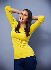 Image showing Woman, laughing and fashion in studio for portrait with arms raised, excited and happy by blue background. Girl, person and model with trendy style, edgy clothes and smile with confidence in Mexico