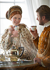Image showing King, queen and couple with tea for royalty, smile and conversation in vintage clothes with style in castle. Woman, man and drink together in morning with Victorian fashion at regal palace in UK