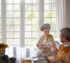 Image showing King, queen and couple with tea in costume, smile and conversation in vintage clothes in castle at breakfast. Woman, man and drink together in morning with Victorian fashion at regal palace in UK