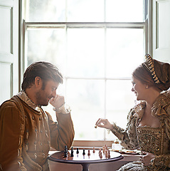 Image showing Renaissance, couple and chess at home with royalty, vintage and medieval costume in a palace. Window, luxury and queen together with smile from strategy game and talking while playing with love