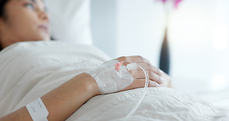 Image showing Woman hand, bed and drip in closeup, clinic and thinking with hydration, liquid or supplement. Person, healthcare and wake up with blood transfusion, anesthesia or pharma drugs for pain in hospital
