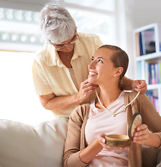 Image showing Senior mother, daughter and necklace for gift on sofa with family inheritance, smile or love in lounge. Elderly mom, person and pearl jewelry for present, vintage style or culture on couch in home