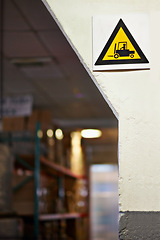 Image showing Warning, sign and forklift with triangle or symbol for alert, precaution or safety at warehouse or factory. Empty room with hazard billboard for beware of vehicle, lifting or transport at manufacture