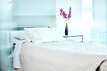 Image showing Flowers, empty and bed at medical hospital for sickness, injury or surgery recovery or resting. Pillow, blanket and comfortable modern interior of ward with floral plant in healthcare clinic.