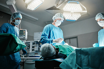 Image showing Doctor, surgery and employees in hospital, theater and emergency room busy in medical career. People, healthcare workers and nurses with patient for procedure, medicine and operation for health