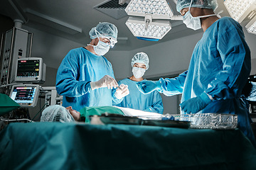 Image showing Surgeon group, people and operating room at hospital in scrubs, ppe and help for emergency healthcare procedure. Doctors, team and together in icu, medical surgery and services for wellness at clinic