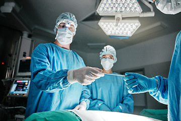 Image showing Doctors, hands and scalpel in operating room at hospital in scrubs, ppe or emergency surgery for health. Surgeon, group and together in icu, medical procedure or giving tools for wellness at clinic