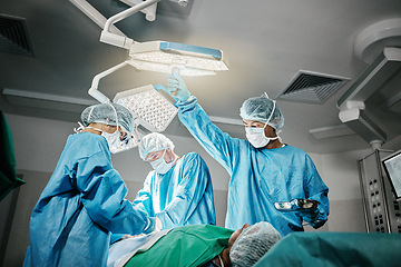 Image showing Healthcare, surgery and doctors with patient in theater for emergency medical procedure. Hospital, lights and surgical team for operation on person together in ICU, professional trust and help.