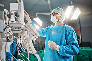 Image showing Healthcare, scrubs and doctor with machine in theatre for surgery, cardiovascular operation or analysis. Medical professional, man and ecg monitor for cardiology, procedure or information in hospital
