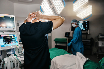 Image showing Surgery, healthcare or doctor with mask in operating room, theater or trauma unit for anatomy emergency. Medical, ppe or man surgeon at hospital with uniform, check or safety for clinician compliance