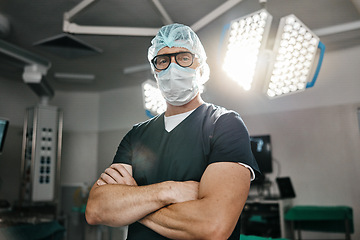 Image showing Surgery, portrait and arms crossed by man doctor in operating room with confidence in medical, healthcare or emergency. Hospital, face mask and male surgeon in theatre with pride, help or leadership