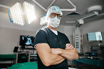 Image showing Portrait, healthcare and arms crossed by man doctor in operating room with confidence in medical, surgery or emergency. Hospital, face mask and male surgeon in theatre with pride, help or leadership