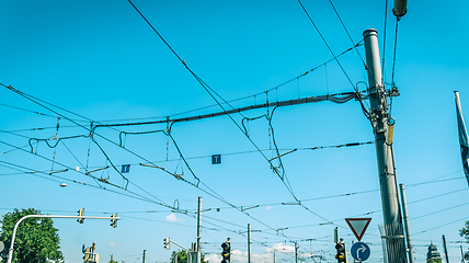 Image showing Electric wiring of city tram and bus traffic against blue sky