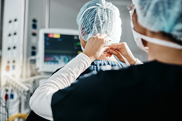 Image showing Healthcare, uniform and doctors in theatre for surgery, procedure or operation in hospital. Medical professional, surgeon and help with clothes for support, safety and cardiology in operating room