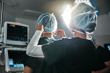 Image showing Healthcare, uniform and surgeon in theatre for surgery, protection and preparation in hospital. Medical professional, doctor and help with clothes for support, safety and procedure in operating room