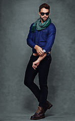 Image showing Fashion, confidence and man or model in studio isolated on a gray background mockup space. Serious, person and roll sleeve on shirt for style in casual clothes, trendy or cool sunglasses with jeans