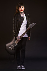 Image showing Portrait, guitar and woman with punk rock, instrument and musician on dark studio background. Person, artist and model with edgy clothes and fashion with creative and culture with rebel and tradition