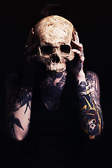 Image showing Skull, tattoo and woman in studio for dark art, abstract horror or scary aesthetic with bone mask. Creative nightmare, halloween culture and unique person in surreal portrait on black background