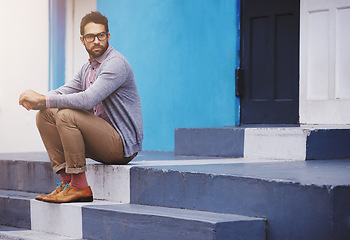 Image showing Man, building and sitting on stairs for fashion, clothes and trendy with glasses outdoor in Cape Town, South Africa. Male person, gen z guy and vision for unique outfit, edgy and urban style