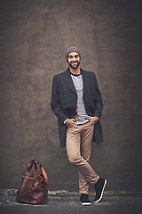 Image showing Man, portrait and smile with downtown, fashion and trendy gentleman jacket. Model, winter and beanie for city, happiness or outdoor positivity for cool hipster style isolated on brown wall background