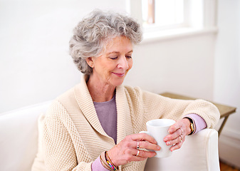 Image showing Coffee, sofa and elderly woman in living room for morning enjoyment, weekend and retirement. Relax, smile and senior female person with happiness for warm drink, beverage and satisfaction at home