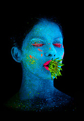 Image showing Neon, paint and face of woman in studio with plant for organic art, plant aesthetic or cosmetics. Glow makeup, person or fluorescent glitter for uv illusion or creative glow on black background