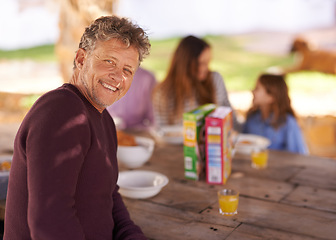 Image showing Portrait, mature and man with smile for picnic with family in nature of backyard of house and outdoor. Women, men and child eating breakfast on table of wood in summer, happiness and love in home