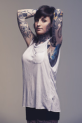 Image showing Portrait, tattoo and punk rock with woman, rebel and creativity on a grey studio background. Heavy metal, artistic or model with confidence or proud with edgy person or trendy with ink or casual girl