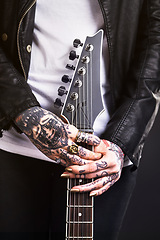 Image showing Metal, woman and guitar on black background for rock culture or grunge, edgy and goth fashion with closeup. Punk star, hands and isolated in studio with instrument for band music with dark leather.