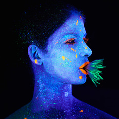 Image showing Neon, paint and creative woman in studio with plant for organic art, psychedelic aesthetic or cosmetics. Glow makeup, person or fluorescent glitter for uv illusion or fantasy glow on black background