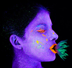 Image showing Neon, paint and creative woman with art in studio or plant for organic creativity, psychedelic aesthetic and cosmetics. Glow makeup, person and fluorescent glitter for uv illusion on black background