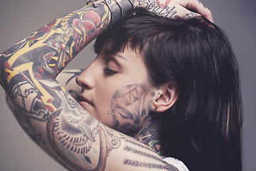 Image showing Tattoo, culture and rebel with woman, punk rock and tradition on a grey studio background. Profile, person and model with ideas and creativity with cool gothic art with ink, trendy and edgy design
