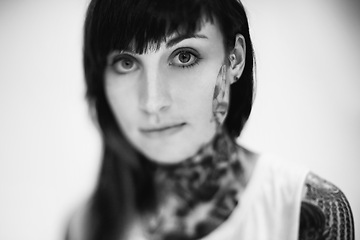 Image showing Portrait, tattoo and gothic woman in a tank top on black and white background for edgy style in studio. Face, unique and female punk model with ink on skin for art, fashion or creative expression