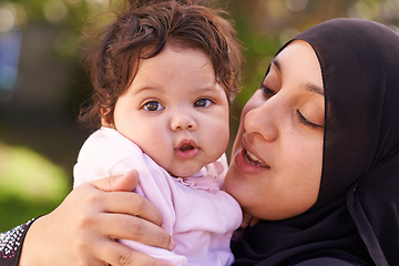 Image showing Muslim woman, mother and baby with hug for love, care and bonding during Eid in Cape Town, South Africa. Female person, child and family together outdoor in nature, garden and backyard with affection