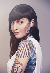 Image showing Happy woman, portrait and tattoo with beauty or skin cosmetics on a gray studio background. Face of young female person, punk or body artist with smile for detail ink, design or cool tattooed art