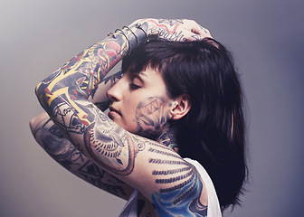 Image showing Tattoo, edgy design and rebel with woman, punk rock and tradition on a grey studio background. Profile, person and model with ideas or creative with emo and gothic art with ink, trendy or heavy metal