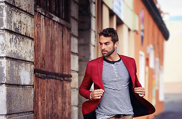Image showing Man, think and fashion in urban outdoor with outfit for casual or smart wear on wall for trends and style. Confident, street and city in elegant clothes with blazer in downtown for classy look