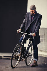 Image showing Bicycle, style and man in city for travel on winter vacation, adventure or holiday with retro fashion. Vintage, stylish and male person on bike for cycling with beanie and coat for outfit in town.