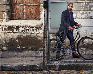 Image showing Bicycle, fashion and portrait of man in city for travel on winter vacation, adventure or holiday with retro style. Vintage, stylish and male person on bike with beanie and coat for outfit in town.