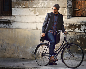 Image showing Bicycle, vintage and man in city for travel on winter vacation, adventure or holiday with retro style. Fashion, stylish and male person on bike for cycling with beanie and coat for outfit in town.