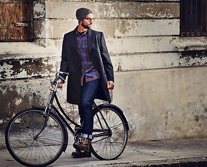 Image showing Bike, fashion and man in city for travel on winter vacation, adventure or holiday with retro style. Vintage, stylish and male person on bicycle for cycling with beanie and coat for outfit in town.