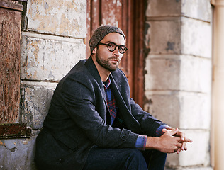 Image showing Fashion, portrait or man in town by a wall or building in casual clothes, style or edgy coat for a winter outfit. Glasses, cool model or stylish male person in modern beanie or trendy jacket in Italy