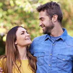 Image showing Couple, outdoor and happy with hug or eye contact for bonding, love and support to relax together. Relationship, romance and smile or fun at park as family, soulmate and commitment on vacation