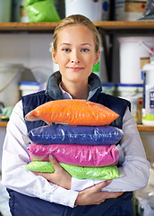 Image showing Woman, bag and plastic in factory, pellets and dye manufacturing and ecology in portrait at store. Person, color and employee for recycling at plant with storage, particles and polymer in warehouse