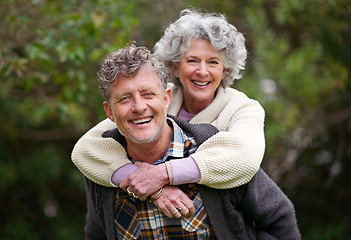 Image showing Portrait, retired people, smile on piggyback to relax in nature park as bonding together on holiday. Happy, older couple or love on fun vacation or walk as romantic date in retirement getaway