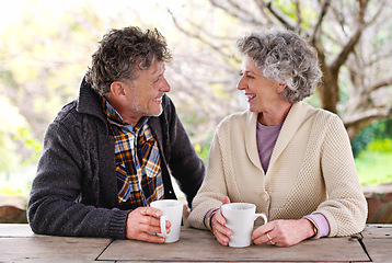 Image showing Senior couple, conversation or coffee to relax in garden as happy, communication or bonding together. Elderly man, woman or smile at hot, drink or table to talk of retirement, marriage or commitment