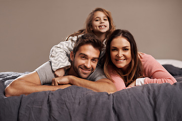 Image showing Parents, child and portrait in bedroom to relax in home for weekend break, family time and happiness for bonding. Father, mother and girl comfy or cozy together for love, care and safety or security.