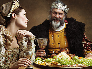 Image showing King, queen and royalty with buffet and wine in banquet hall for fine dinning for tradition or culture in palace. Monarch, sovereign and together with feast for luxury, bored and vintage with goblet.